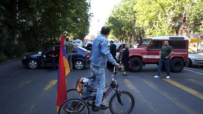 A supporter of opposition lawmaker Nikol Pashinian looks at people blocking a road in the Armenian capital Yerevan on Wednesday, May 2, 2018. AP