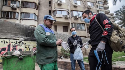 Volunteers distribute masks and gloves to a sanitation worker in a Cairo street. AFP