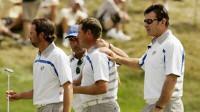 Europe's Sergio Garcia, left, and Lee Westwood, second from right, are congratulated by team captain Nick Faldo, right, and Jose Maria Olazabal after halving their match.