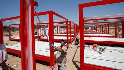 A worker paints frames of containers to be used for a coronavirus quarantine centre in the Gaza Strip. Reuters