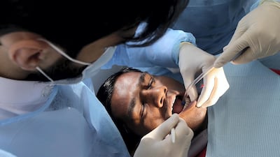 Abul Khiar gets a free dental checkup at Ajman University's mobile clinic. Satish Kumar for the National