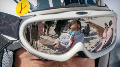 A staff member wearing a face maskis reflected in the goggles of a skier at the National Alpine Skiing Center in Yanqing on the outskirts of Beijing. Beijing Olympic organisers showed off the downhill skiing venue and the world's longest bobsled and luge track Friday, one year ahead of the scheduled opening of the 2022 Olympic Winter Games. AP Photo