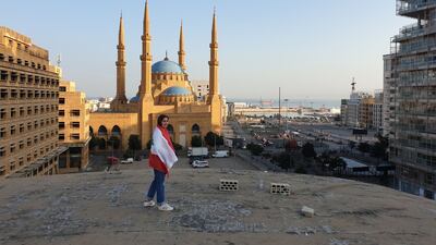 Grace Dergham draped in a Lebanese flag in Downtown Beirut in a public protest in 2019