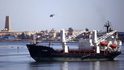 A military helicopter flies above a container ship in the Suez Canal. Amr Abdallah Dalsh / Reuters