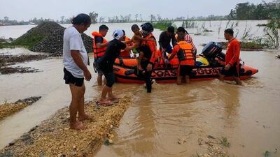 Coastguard personnel carry out rescue operations in a flood-affected village in Kabangkalan City. EPA