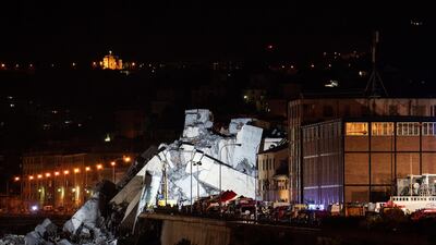 Emergency personnel search through debris from the collapsed Morandi motorway bridge at night in Genoa. Bloomberg