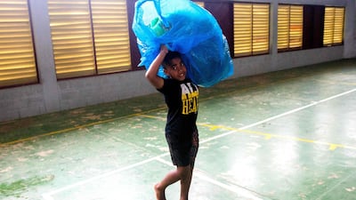 A Fijian boy carries a bag to a temporary shelter. AFP