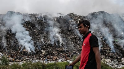 A man walks past burning rubbish at a landfill site on the artificial island of Thilafushi near Male, Maldives. Carl Court / Getty