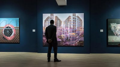 A viewer stands at the centre of the exhibition, in front of a piece by Driss Ouadahi. Photo by Christina Dimitrova, courtesy of Barjeel Art Foundation, Sharjah