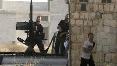 A Free Syrian Army fighter fires an anti-aircraft gun as a Syrian Air Force fighter bomber fires rockets during an air strike in the village of Tel Rafat, some 37 km north of Aleppo. Hundreds of foreign fighters have been flooding into Syria to fight to topple Bashar Al Assad.