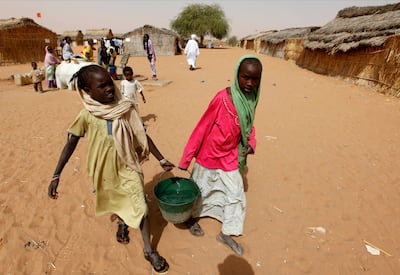 Displaced Sudanese girls carry water in the Zamzam camp. AP
