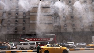 Water-spraying fans on the streets of Baghdad on June 11. Many Iraqis attribute electricity shortages to corruption, as well as years of conflict. AFP
