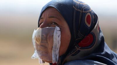 A Palestinian woman wears a mask containing an onion to protect herself from Israeli tear gas during protests on the Israel-Gaza border in 2018. Reuters