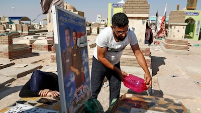 Iraqis clean and mourn over the graves of relatives killed in the combat against ISIL at the Wadi Al Salam cemetery in the Shiite holy city of Najaf on Eid Al Adha on September 1, 2017. Haidar Hamdani / AFP