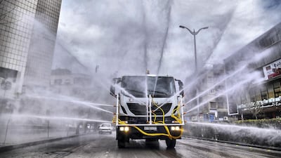 Syrian Red Crescent vehicles spraying disinfectant along a street in the capital Damascus. AFP