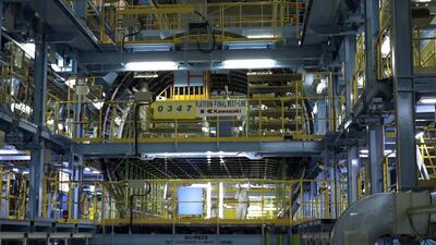 A worker is seen inside Kawasaki Heavy Industries' newly built manufacturing plant in Yatomi, central Japan. The company's shares plummeted after it gave a warning on profits. Tim Kelly / Reuters