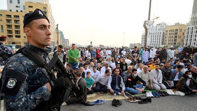 A soldier stands guard as people participate in the Eid al-Fitr prayers next to the 'Revolution Fist', outside Al-Amin Mosque in Martyr's Square, downtown Beirut, Lebanon. EPA