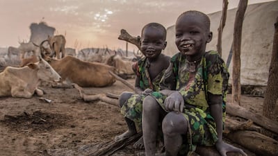 Two boys smile for the camera at the cattle camp.