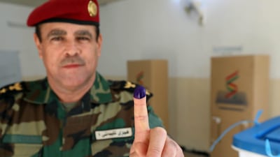 A member of a Kurdish Peshmerga shows his ink-stained finger after casting his vote for the parliamentary election in Iraq's autonomous Kurdish region. AFP