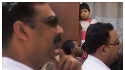 A little girl waits for the end of Good Friday service at St Joseph's where thousands gathered for the Good Friday service on Friday, April 18, 2014, in Abu Dhabi. Delores Johnson / The National