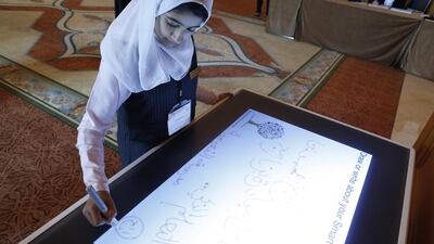 AlReem Rashid Ahmed uses a digital pad at the Mohammed Bin Rashid Smart Learning Programme awards ceremony in Dubai. The tablet computer technology converts a user’s handwriting into a test that can be stored electronically for later use or for e-mails. Antonie Robertson / The National