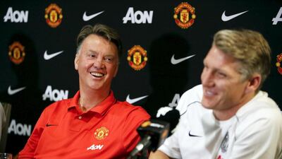 Manchester United manager Louis van Gaal smiles next to Bastian Schweinsteiger at his introductory press conference in July. Jason Redmond / Reuters / July 15, 2015