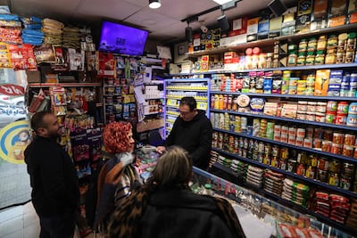 A shop owner serves customers in Tehran. Sanctions have badly damaged Iran's economy. AFP
