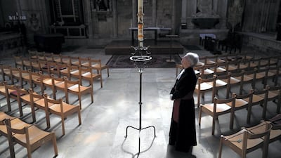 Canon Maggie McLean, the canon missioner at York Minster, lights the Paschal Candle in memory of victims of coronavirus in May. York Minster launched a new initiative for worshipers to email a request for their loved one to be remembered in a prayer that would be said by clergy at the Paschal Candle. Getty Images