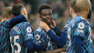 Arsenal's Bukayo Saka, centre, celebrates after scoring the opening goal against Norwich City at Carrow Road. AFP