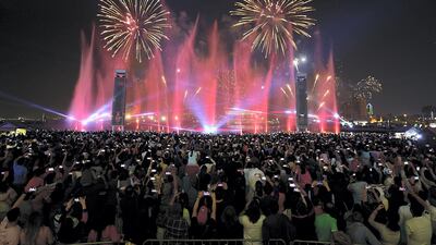 People enjoy the fireworks at Dubai Festival City in Dubai on Monday. Satish Kumar/ for The National