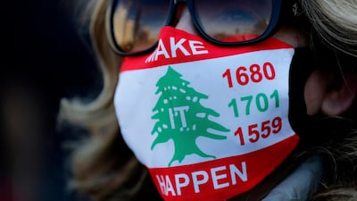 An activist in a coronavirus mask bearing the colours of the Lebanese flag and the UN resolution numbers calling for the disarmament of all Lebanese and non-Lebanese militias. She was at a sit-in in Beirut, Lebanon, to mark the 47th anniversary of the 1975-1990 civil war, in which more than 150,000 people were killed. AP Photo