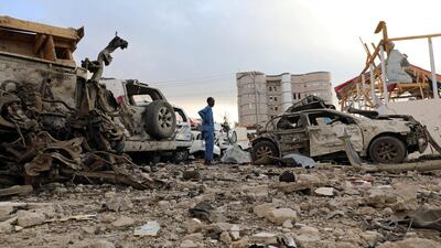A security officer from Doorbin Hotel assesses the debris after a suicide car explosion in front of the hotel in Mogadishu, Somalia. Feisal Omar / Reuters