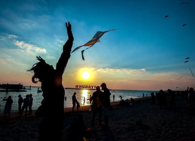 A girl jumps as she lets go of her kite at the Hudayriyat International Kite Festival in Abu Dhabi. Victor Besa / The National