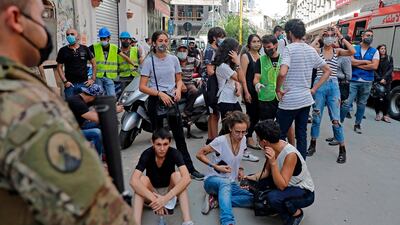 Bystanders gather as rescue workers dig through the rubble of a badly damaged building in Lebanon's capital Beirut, in search of possible survivors from a mega-blast at the adjacent port one month ago, after scanners detected a pulse. Lebanese rescuers scoured rubble for a possible survivor in Beirut after the detection of a pulse drew crowds hopeful of a miracle one month on from a devastating explosion. AFP