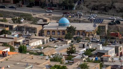 Taliban fighters and Kabul residents gather at the mosque after the blast.