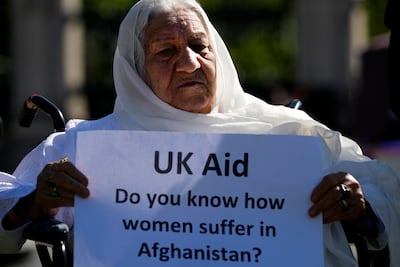 Kokogul, 80, holds a sign urging Britain to intervene. AP