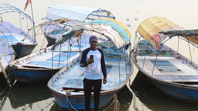 Indian boatman Rinku Nishad, 35, poses with his smartphone on the banks of the river Ganges in Allahabad. AFP