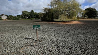 A ’No Fishing’ sign is pictured in the dried up Falmer Pond in Falmer, East Sussex, south of London. Climate change has intensified a drought across Europe this summer, with extreme heat driving the exceptionally dry conditions, according to experts. AFP