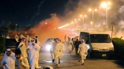Thousands of angry protesters run for cover as Kuwait riot police use stun grenades and tear gas to disperse them.
