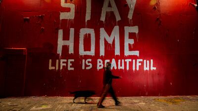 A man walks by a mural, made during the Covid-19 pandemic by Mr Brainwash on La Brea Avenue, on April 18, 2020, in Los Angeles, California. Getty Images