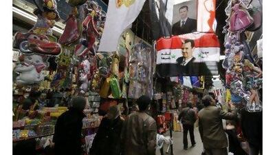 A portrait of the Syrian president Bashar Assad dominates a shopping alley in Damascus. A reader says that Syria has not experienced political unrest because the people genuinely like their president. Hussein Malla / AP