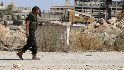 A lone rebel fighter walks by damaged buildings near Castello Road the vital supply road which runs from the Turkish border to Aleppo, Syria , on September 16, 2016. Abdalrhman Ismail / Reuters