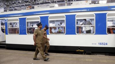Security personnel walk past a passenger train at Fort train station in Colombo. EPA