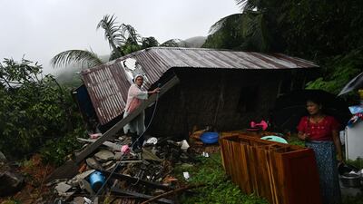 Residents sort through belongings salvaged from a building damaged in the landslide. AFP