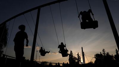 People ride swings at a playground in Gorky Park in Moscow, Russia. Reuters