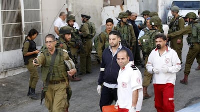 An Israeli officer allows Palestinian paramedics to approach after removing the body of a Palestinian man shot dead for what the Israeli military said was a stabbing attack in Tal Rumaida, in the West Bank city of Hebron, on September 17, 2016. Abed Al Hashlamoun / EPA