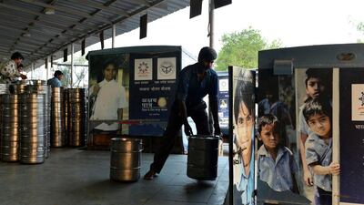 An Indian labourer loads containers of food onto a truck at the non-profit Akshaya Patra Foundation.