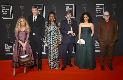Booker Prize 2025 winner David Szalay (centre) with judges Sarah Jessica Parker, Chris Power, Ayobami Adebayo, Kiley Reid and chair of the judging panel Roddy Doyle (from left) during The Booker Prize 2025 ceremony at Old Billingsgate in London. Getty Images