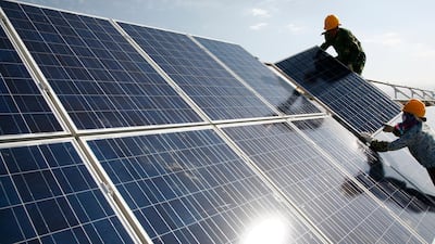 Workers install solar panels at a photovoltaic power station in Hami in northwestern China. The world's second-biggest economy installed 136 gigawatts of renewables capacity last year, 49 gigawatts of which was solar. AP Photo