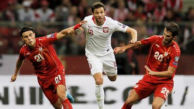 Poland's Bartosz Bereszynski, centre, and Stefan Spirovski, right, and Elif Elmas of North Macedonia during the Euro 2020 qualifying match at the PGE National Stadium in Warsaw. EPA